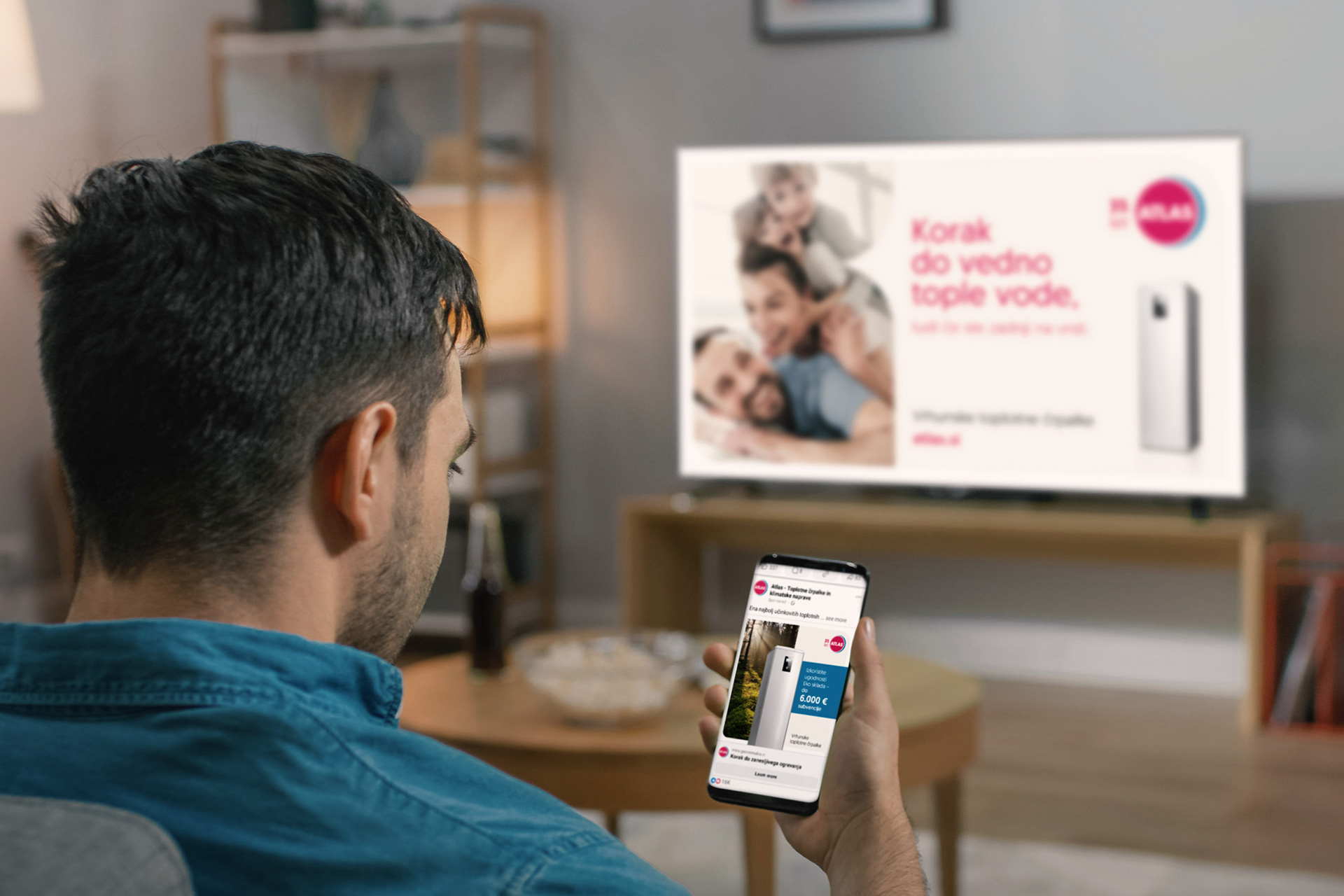 Par gleda oglas za Atlas toplotne črpalke na televiziji in telefonu 