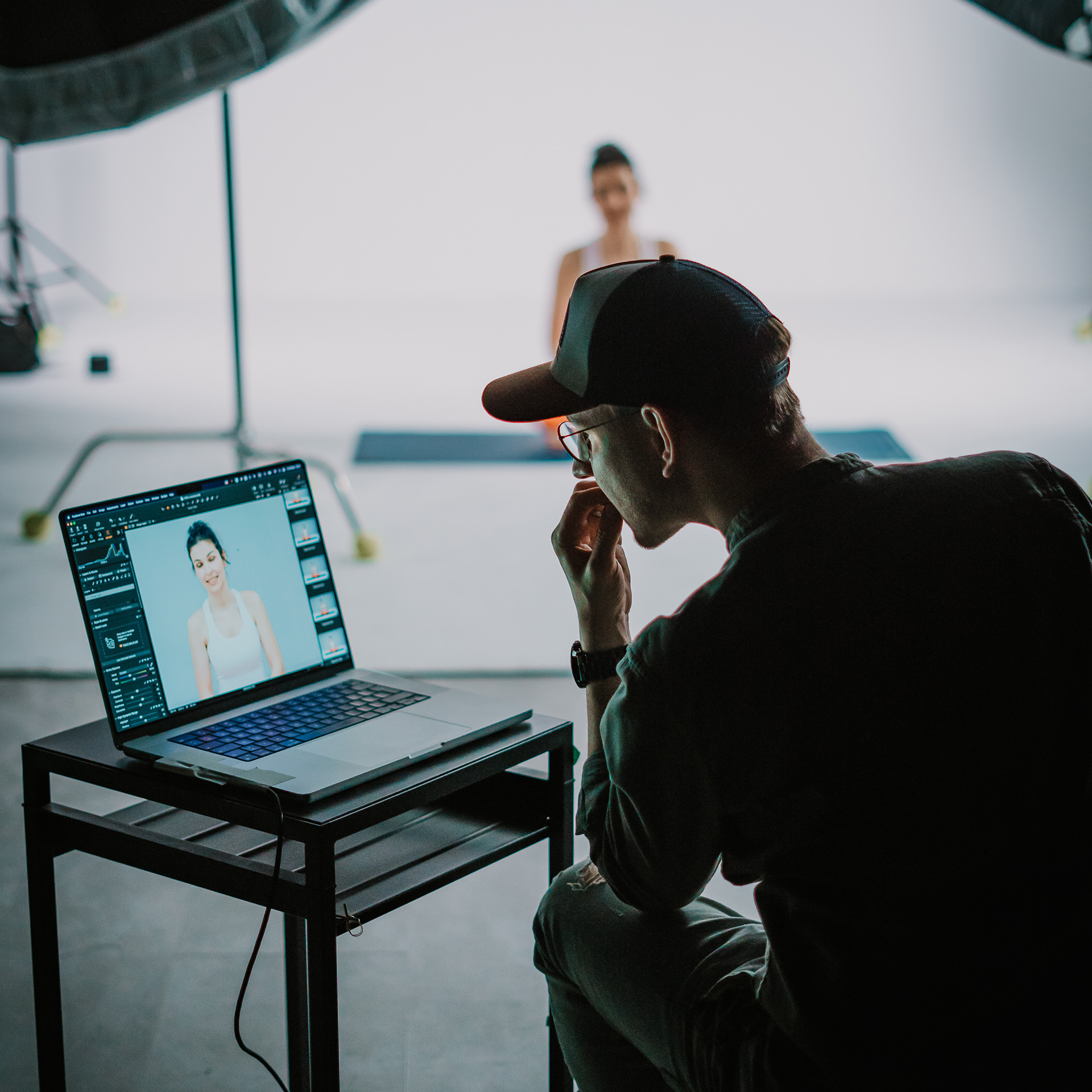 Photo from the shoot. Photographer looking at a photo of a model on a laptop.
