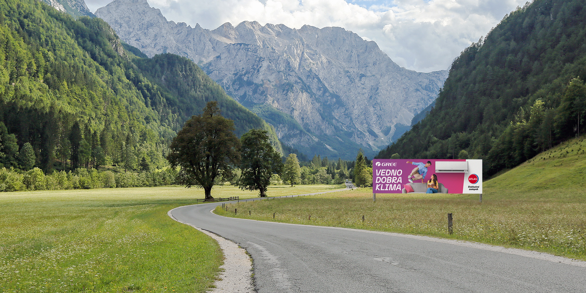 A giant poster with the campaign's main creative motif placed in nature along a local road.